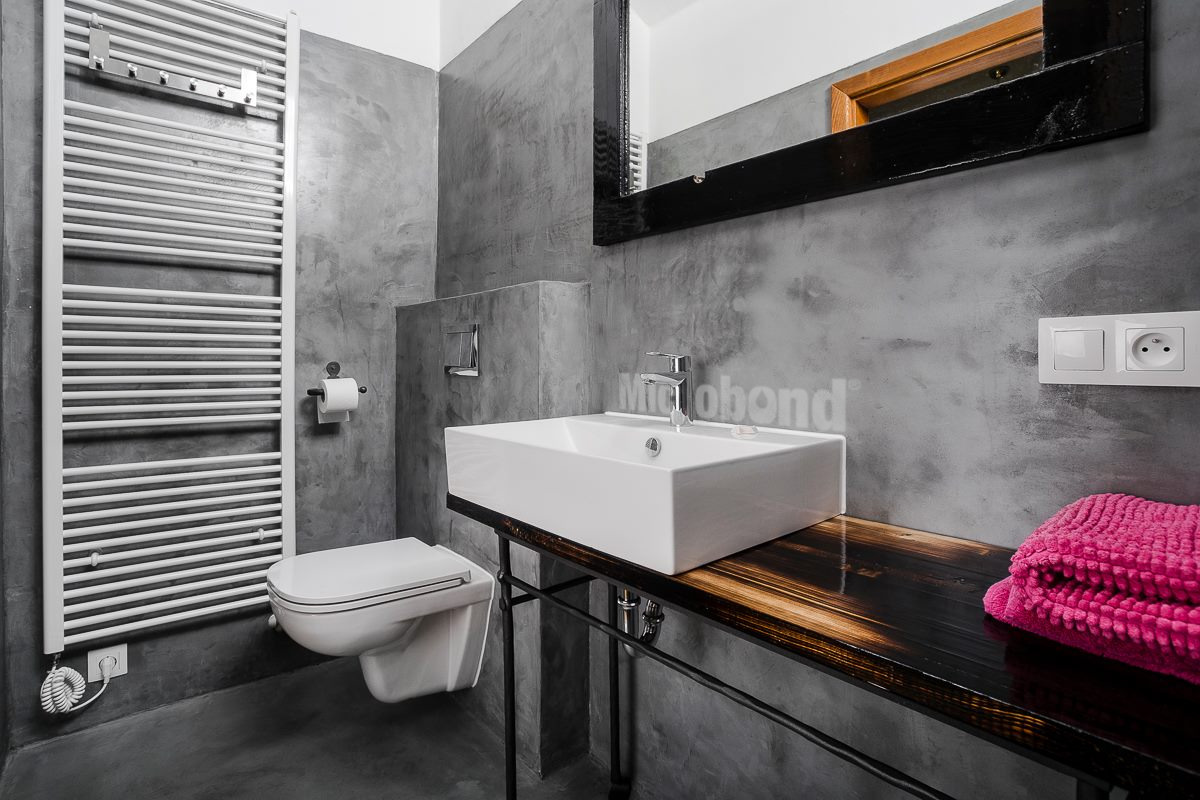 Pareti e pavimento del bagno con una particolare e personalizzata finitura in microcemento Microbond nelle tonalità del grigio.