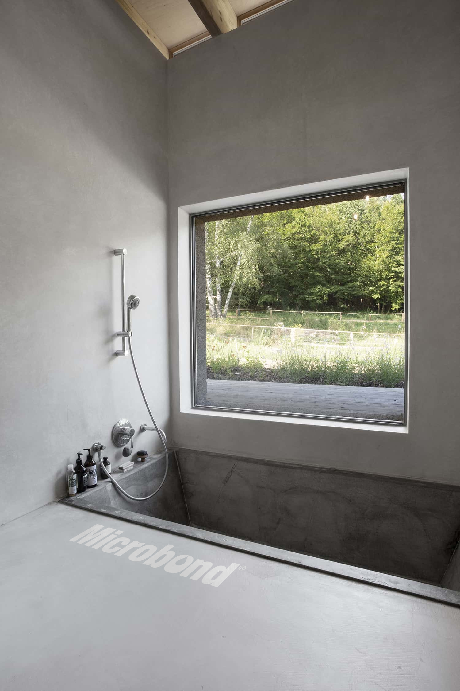 Interessante progetto di vasca da bagno in un contesto moderno, decorata con rivestimento cementizio Microbond.