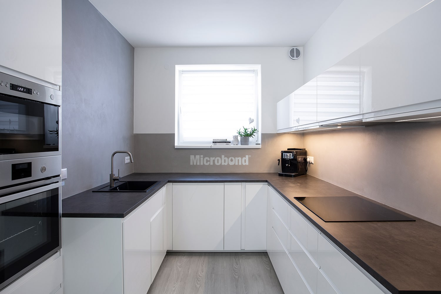 Eleganti e moderne pareti della cucina rivestite in microcemento grigio.