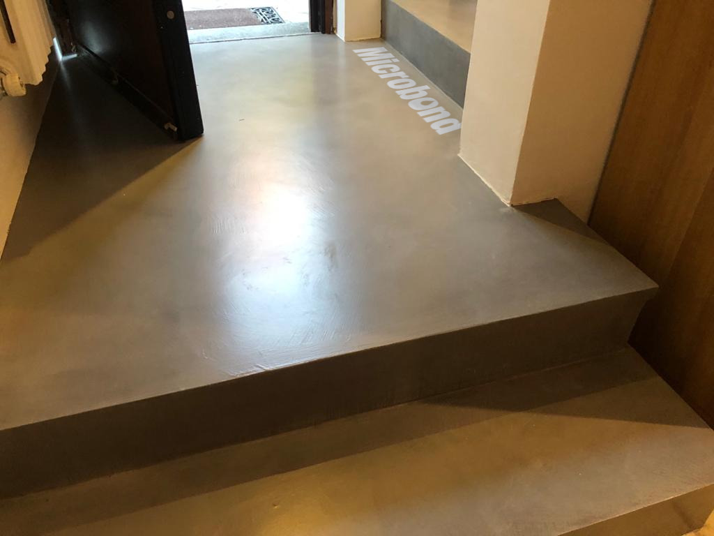 Gradini rivestiti in microcemento in continuità con il pianerottolo d'ingresso