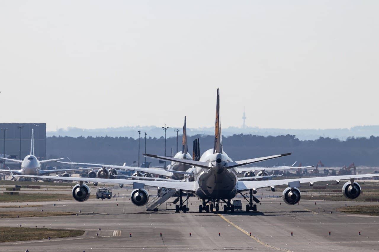 Pista aeroportuale in calcestruzzo con alcuni aerei parcheggiati